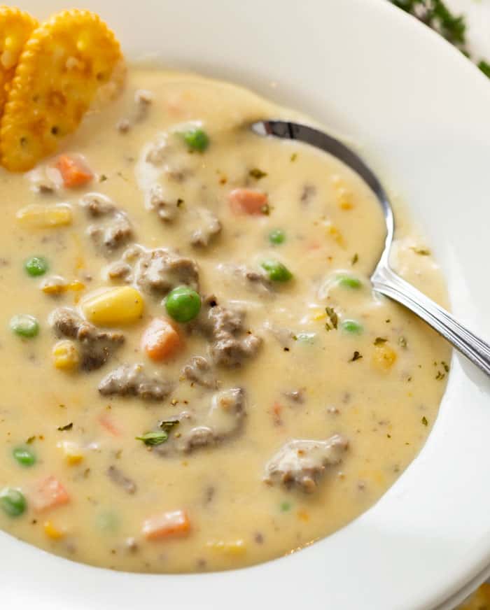 A spoon in a white bowl full of creamy Shepherd's Pie Soup.