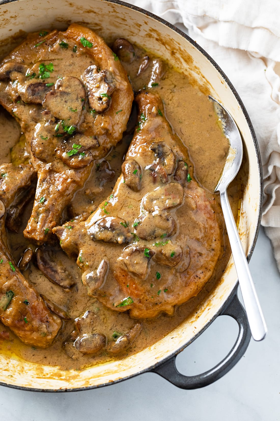 Mushroom Pork Chops in a skillet with gravy.