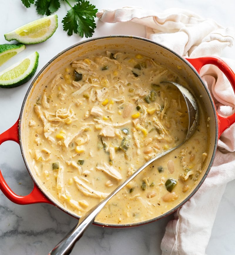 A soup pot filled with White Chicken Chili with a ladle in it.